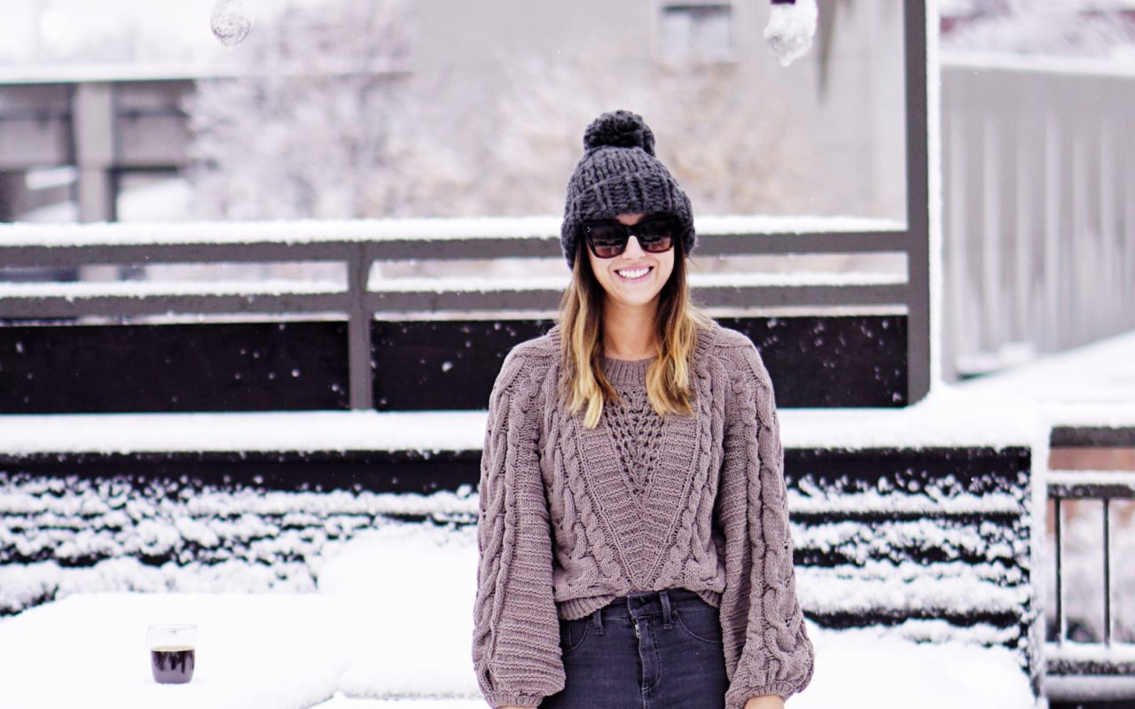 express grey chenille sweater with grey chunky beanie on snowy rooftop