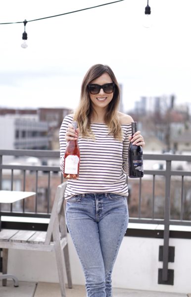 blogger holding rainstorm wine pinot noir and rose on rooftop