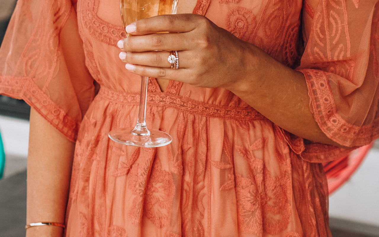 the lotus boutique blush lace dress holding champagne