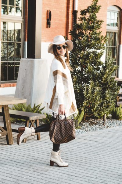 white poncho with faux leather leggings and hiker boots
