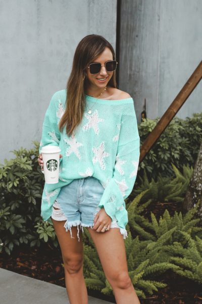 vici sea green star sweater with ripped denim shorts