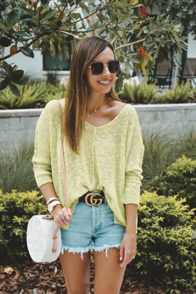 lime sweater with white rattan bag