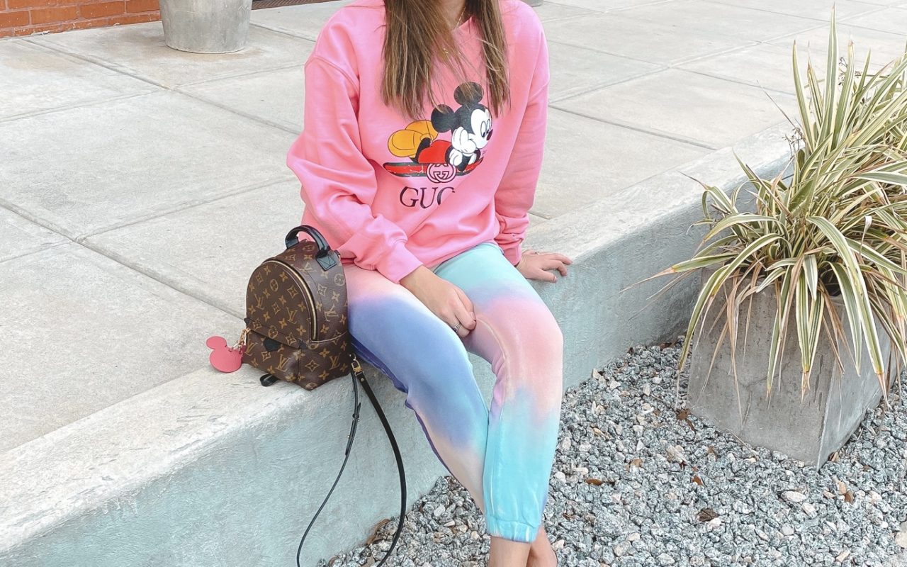 pink gucci disney sweatshirt with tie die joggers and louis vuitton palm springs