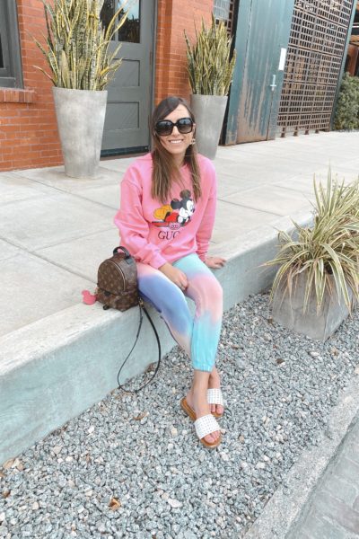 pink gucci disney sweatshirt with tie die joggers and louis vuitton palm springs
