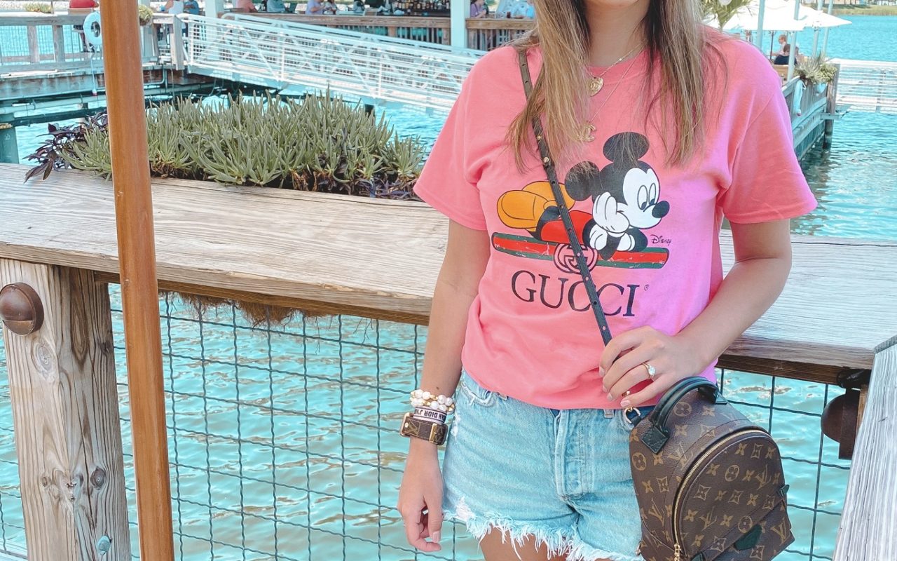 pink mickey mouse gucci disney tee with agolde shorts and louis vuitton palm springs mini