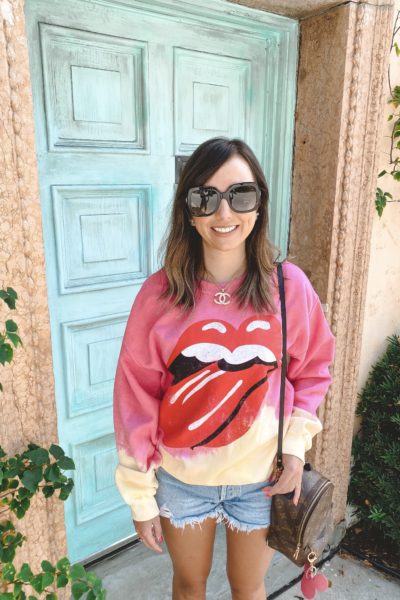 rolling stones tie dye sweatshirt with louis vuitton palm springs and agolde shorts