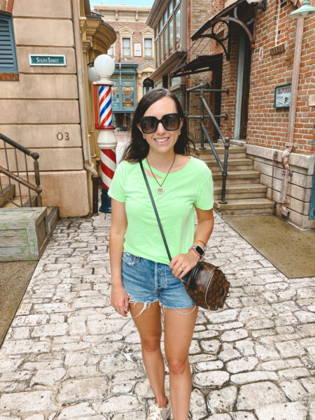 neon green distressed tee with agolde denim shorts at universal studios