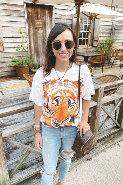 wrangler white tiger tee with ripped denim and louis vuitton palm springs bag