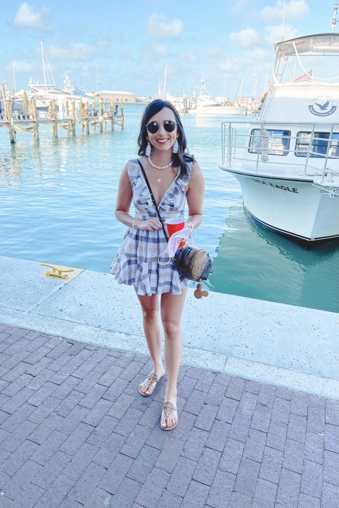taupe plaid romper in front of boat in key west