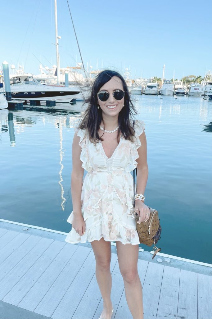 salt water luxe dress with pearl necklace and louis vuitton palm springs mini