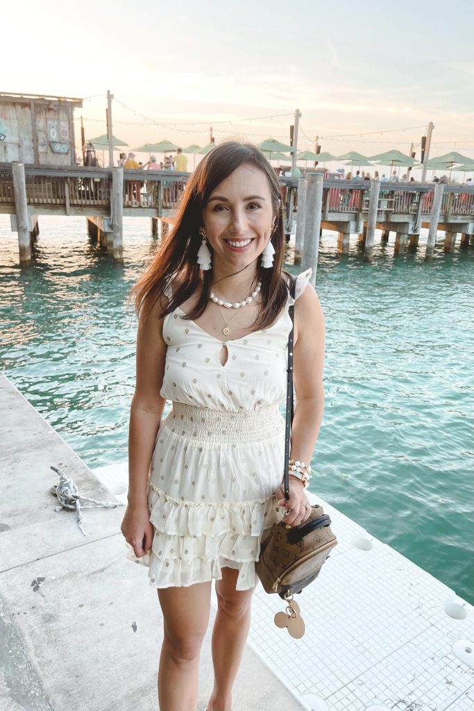 salt water luxe california dress with tassel earrings in front of pier