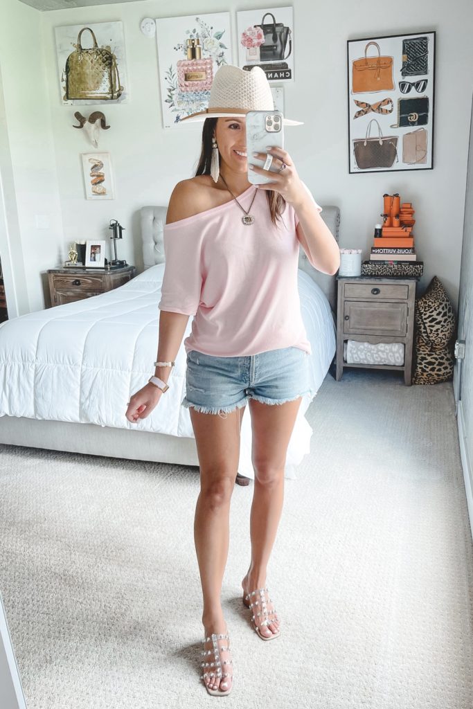 amazon pink off the shoulder tee with agolde denim shorts and white hat