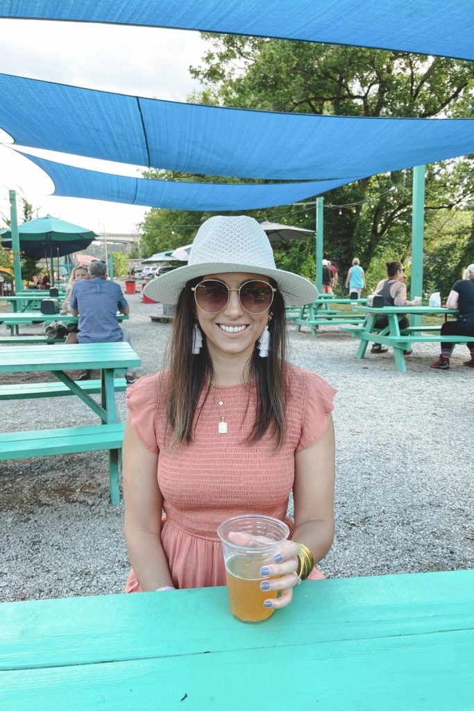 rust smocked dress with white hat at new belgium