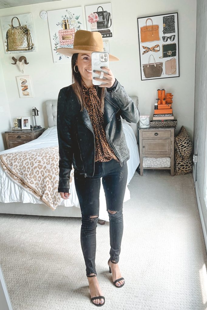 faux leather black moto jacket with black skinny jeans and lack of color hat