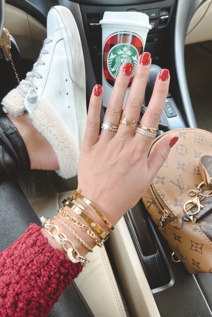 dnd sparkly red manicure for christmas with golden goose shearling mules and bracelets