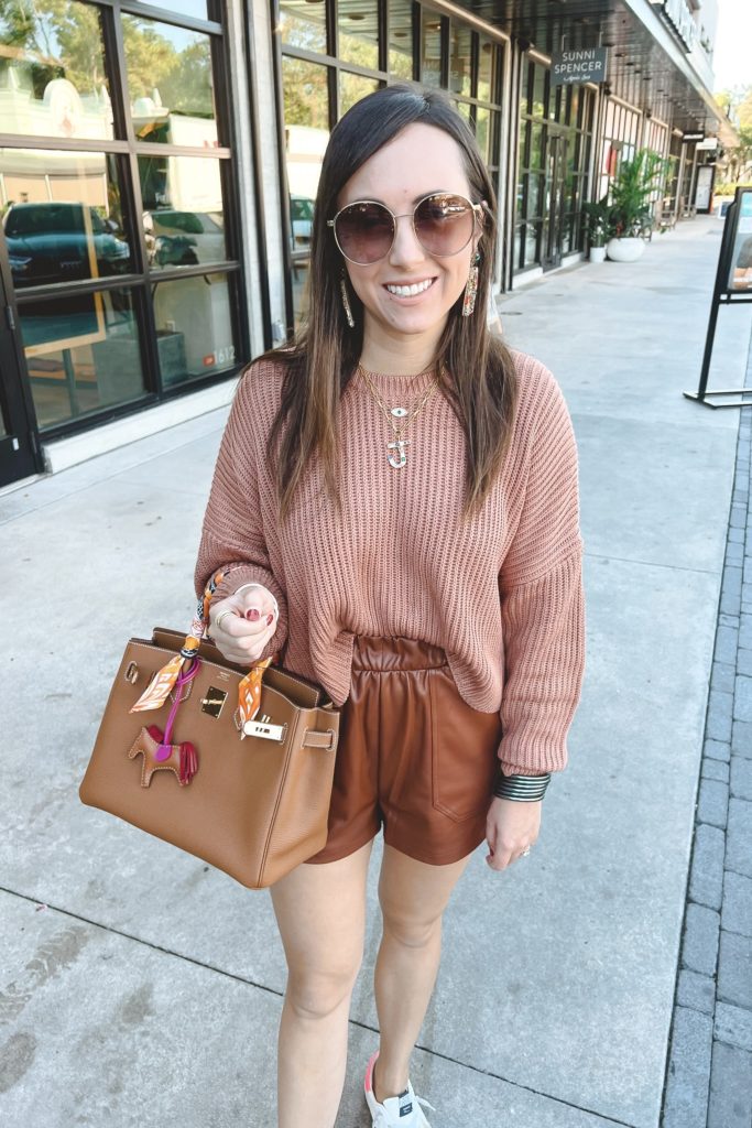 at the office sweater with camel leather shorts and hermes birkin