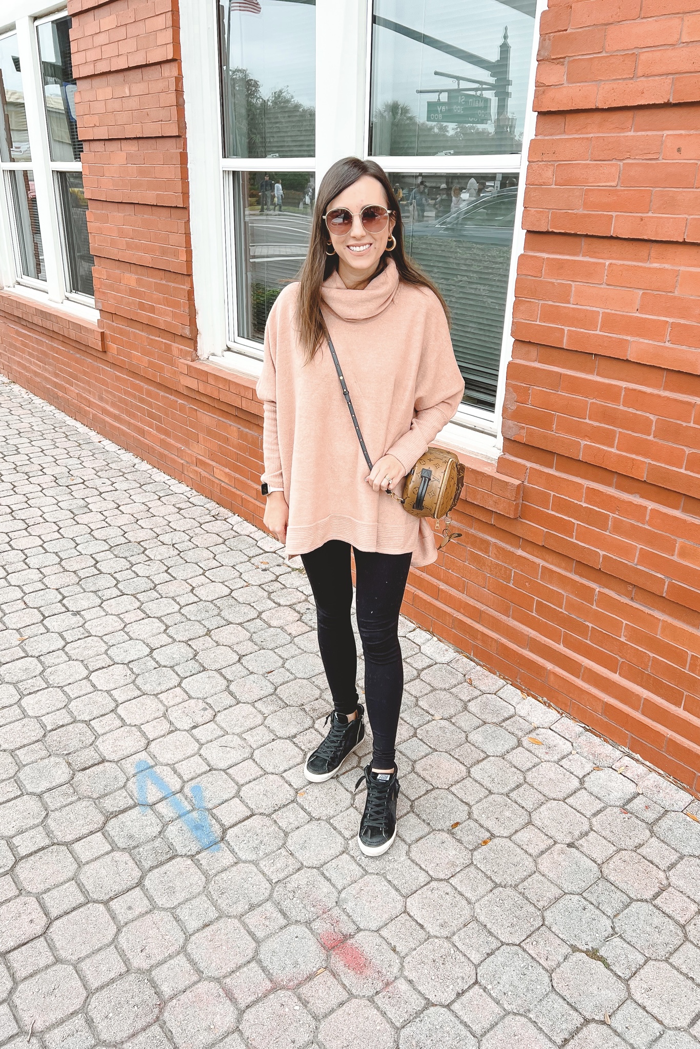 pink lily we can go the distance sweater with black leggings and golden goose sneakers