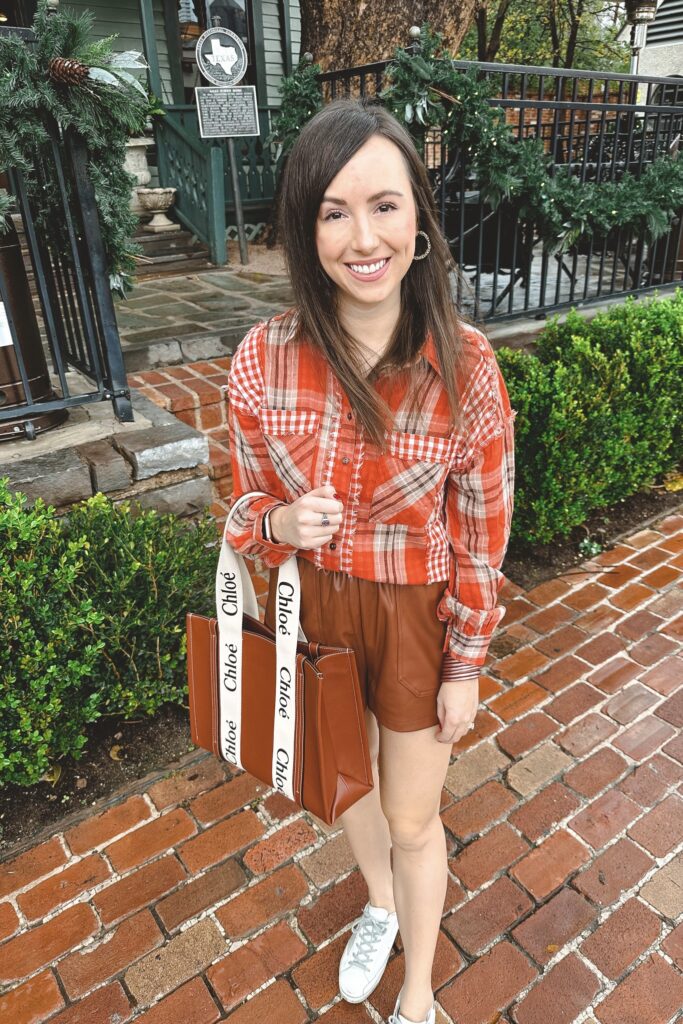 red plaid button down with brown faux leather shorts and chloe woody tote