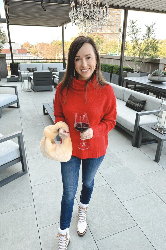 red turtleneck sweater with jeans and shearling bag