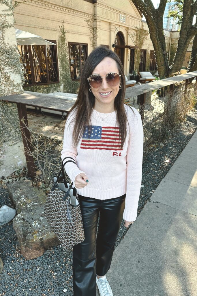 Ralph lauren pink flag sweater with black faux leather pants and goyard tote