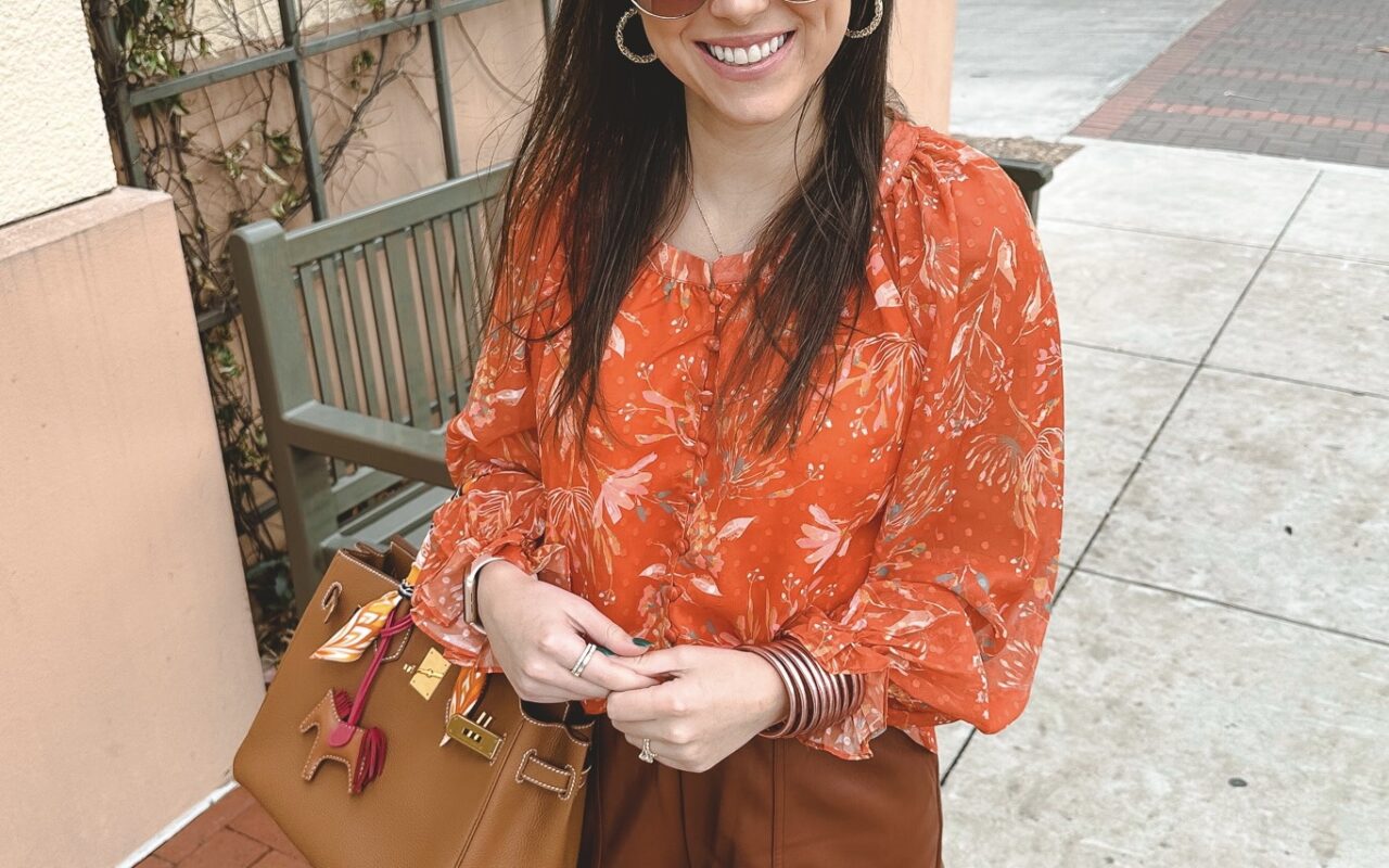 orange floral blouse with brown faux leather shorts and hermes birkin