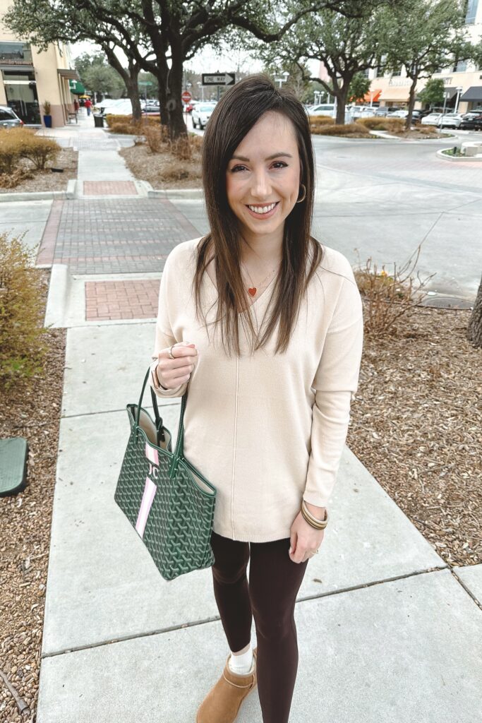 cream sweater with brown leggings and green goyard tote
