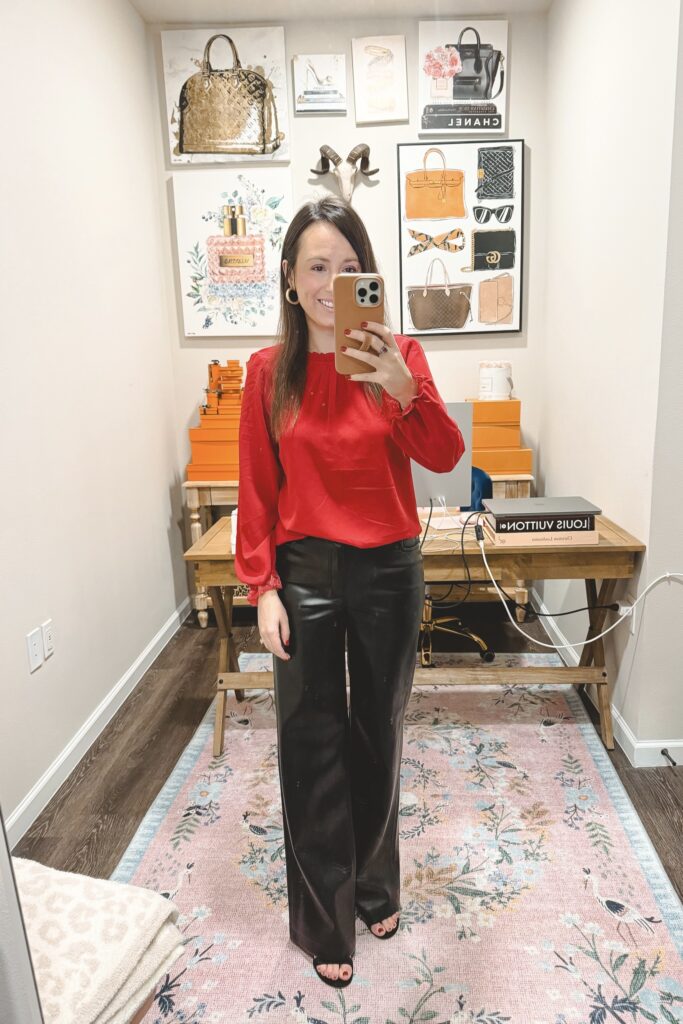 Amazon red ruffle neck blouse with black faux leather wide leg pants and black heels