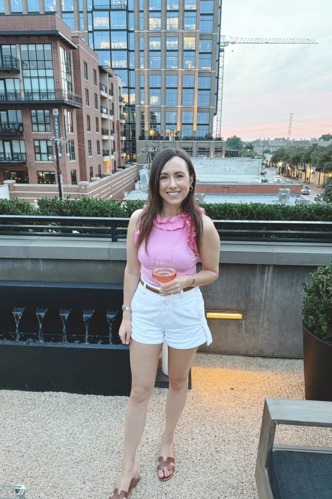 Amazon ruffle pink sleeveless bodysuit with white denim shorts and hermes gold oran sandals