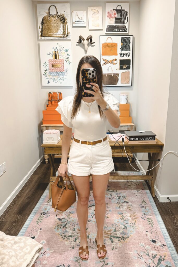 White ruffle sleeve bodysuit with white denim shorts and hermes gold picotin