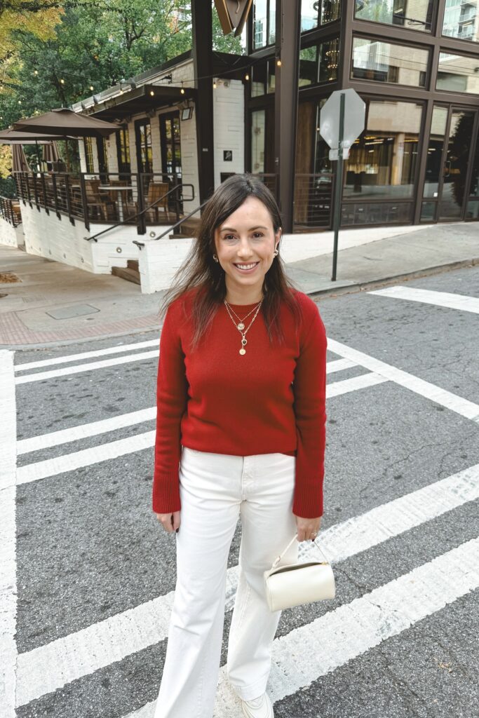 Vince red sweater with ecru baggy jeans and ivory the row 90s bag